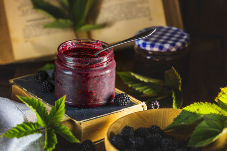 Fresh homemade easy blackberry filling in to the jar. Old dark rustic magic style. Sunny light. Shallow depth of the fieldの写真素材