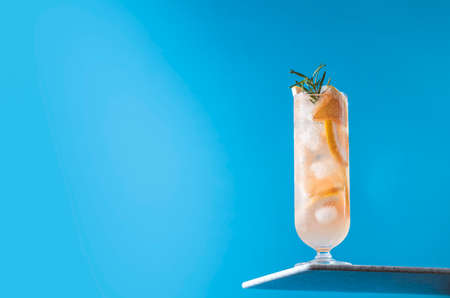 Glass of fresh paloma cocktail on bright blue background. Spring summer art drink food concept.の写真素材
