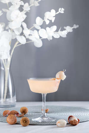 Pink Lychee Cocktail. Champagne coupe glass filled with pink lychee cocktail or mocktails surrounded by ingredients and bar tools.の写真素材