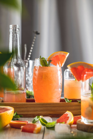 Refreshing grapefruit cocktail with ice and mint is standing on a wooden trayの写真素材