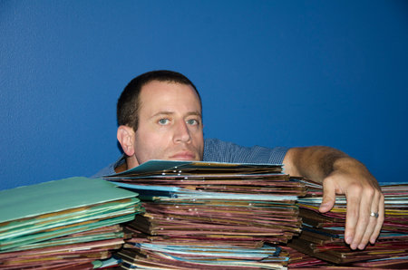 Man bored at work with too many files to review.