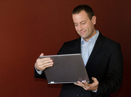 Man looking at his laptop in business attire.