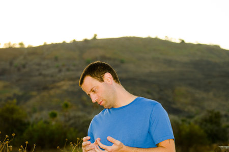 Nervous agitated man playing with his hands outdoors.の写真素材