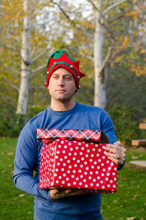 Man holding Christmas presents thinking about the Holiday season.の写真素材