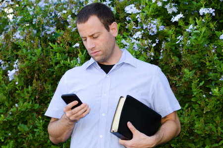 Bible or cell phone? Man choosing smart phone over his Bible.
