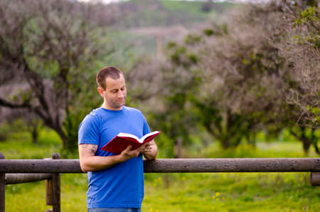 Man reading a book outside in a rural environment.の写真素材