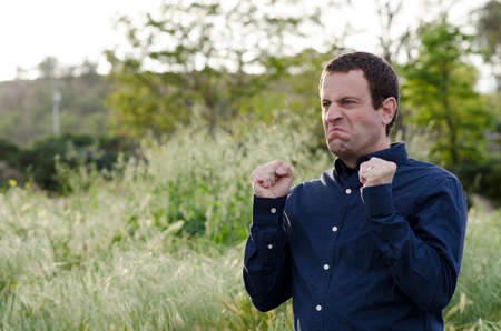 Angry man outdoors with fist clenched making an angry face.の写真素材