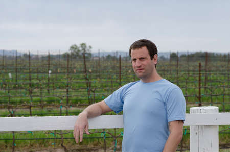 Man relaxing outside in a vineyard. Hopeful for tomorrow.の写真素材