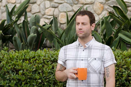 Successful man outside holding an orange coffee mug.の写真素材