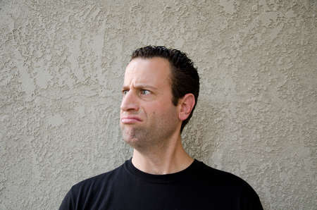 Man making a disgruntled face looking to the left.の写真素材