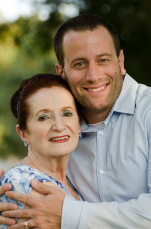 Closeup of adult son hugging his senior mother.の写真素材