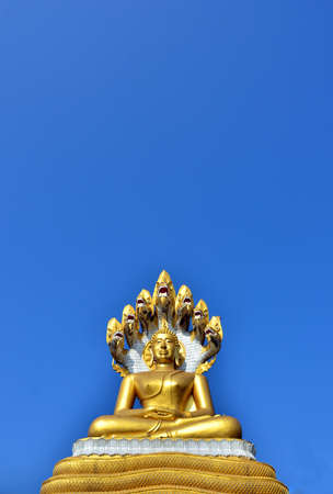 Gold Buddha statue over blue sky の写真素材