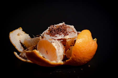 Half peeled mandarin on a black background close-upの写真素材
