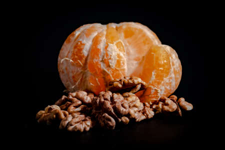 Half peeled mandarin on a black background close-upの写真素材