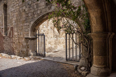 Arch with a gate in the wall of stone in Greeceの写真素材