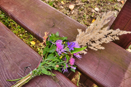 Bouquet of wildflowers on a park bench in autumn 2019の写真素材