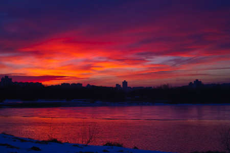 Winter pink evening over the river. Silhouette of the cityの写真素材