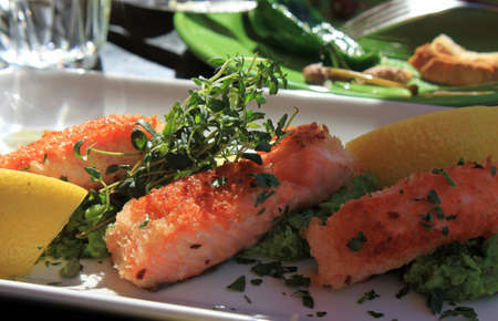 Red fried fish with slices of lemon and herbs.の写真素材