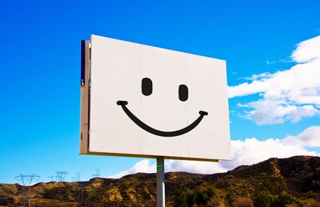White roadside billboard with smiley on the sky backgroundの写真素材