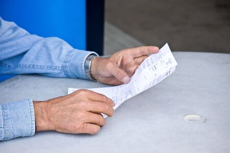 a man reading a bill in his handsの写真素材