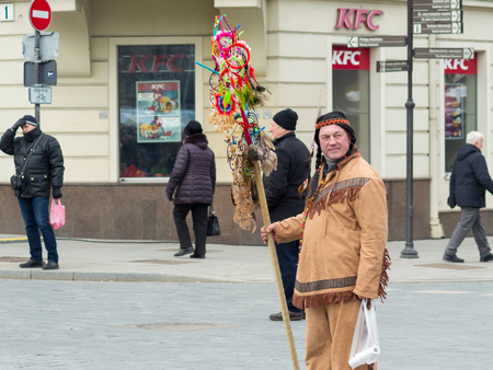 Vilnius/Lithuania - March 3, 2019: St. Casimir's Fair. A man with Indian clothes selling dream catchers in front of KFC restaurant.のeditorial素材