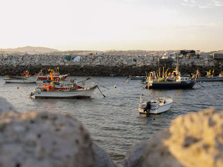 Fishing Boats docked in the shore on sunset time in Trafaria, Portugalのeditorial素材