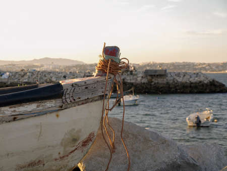 A fishing boat in in the shore next to otheers boats in Trafaria, Portugal.のeditorial素材