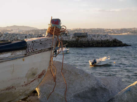 A fishing boat in in the shore next to otheers boats in Trafaria, Portugal.のeditorial素材