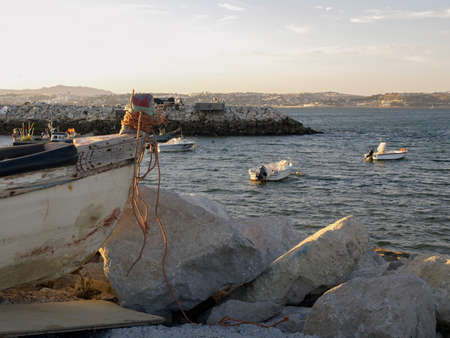 A fishing boat in in the shore next to otheers boats in Trafaria, Portugal.のeditorial素材