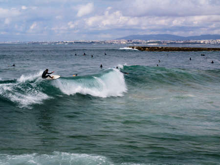 A surfer surfing a wave in Costa da Caparica, Portugal in October 2018.のeditorial素材