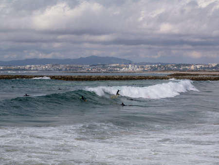 Group of people catching waves on 10 of October in Costa da Caparica, Portugal.のeditorial素材