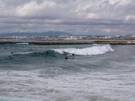 Group of people catching waves on 10 of October in Costa da Caparica, Portugal.のeditorial素材