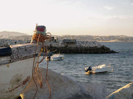 A fishing boat in in the shore next to otheers boats in Trafaria, Portugal.のeditorial素材