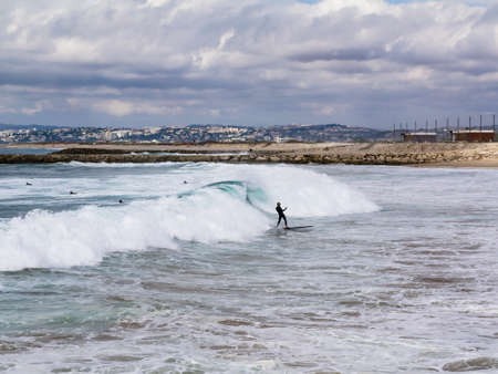 A surfer with a happy atttiude after catching is perfect wave of the moorning on 10/10/2018 in Costa da Caparica, Portugal.のeditorial素材