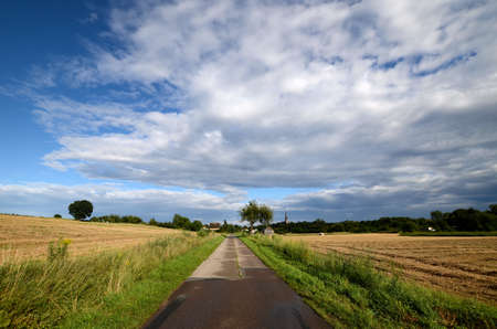 Country road under a cloudy skyの写真素材