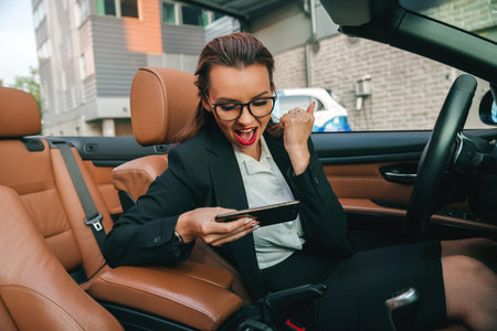 Happy young female playing mobile games in the car.