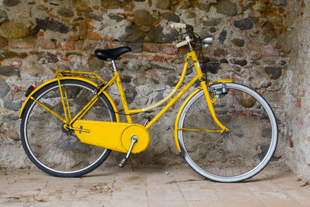 Old yellow bike on the wallの写真素材
