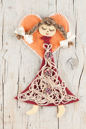 Sewn angel doll on wooden background