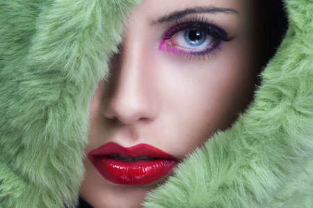 Portrait of young beautiful woman with green fur の写真素材