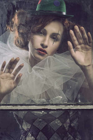 Sad Pierrot woman behind the glassの写真素材