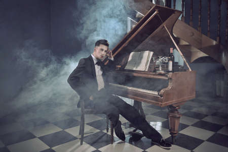 Elegant young man with pianoの写真素材