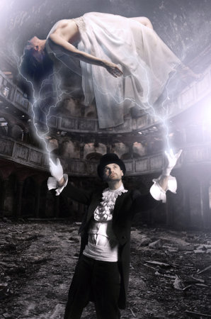 Magician performs magic with beauty girls in airの写真素材