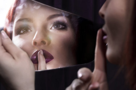 Young woman looking into a mirror