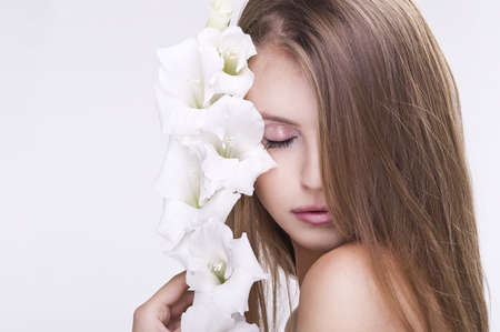 Beauty face of the young beautiful woman with flowerの写真素材