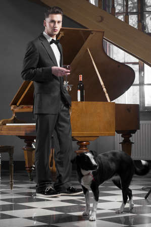 Young pianist with glass of wineの写真素材