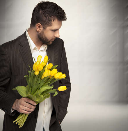 Elegant man holding flowersの写真素材