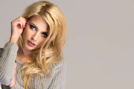 Portrait of wonderful young blonde woman with long hair looking at camera, smiling.の写真素材