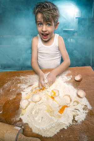 Little chefs enjoying in the kitchen making big messの写真素材