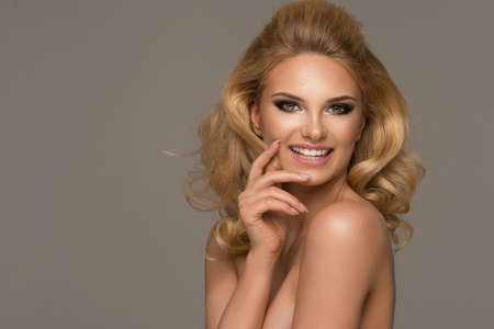 Sensual beautiful blonde woman posing. Girl with long curly hair.の写真素材