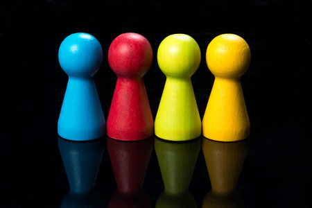 Colored pawns, working together conceptual on wood table